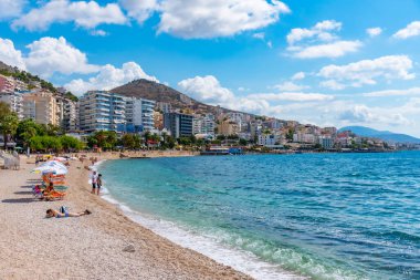SARANDE, ALBANIA, 26 Eylül 2019: İnsanlar Arnavutluk 'un Sarande kentindeki bir plajda güneşli bir günün tadını çıkarıyorlar