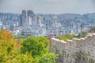 SEOUL, KOREA, 19 Ekim 2019: Seul silueti Kore Cumhuriyeti Namsan Parkı 'ndaki bir şehir duvarının arkasında görülüyor
