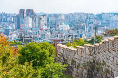 SEOUL, KOREA, 19 Ekim 2019: Seul silueti Kore Cumhuriyeti Namsan Parkı 'ndaki bir şehir duvarının arkasında görülüyor