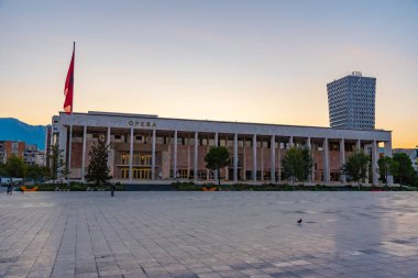 TİRAN, ALBANIA, SEPTEMBER 29 Eylül 2019: Arnavutluk 'un Tiran kentindeki Skanderbeg meydanındaki kültür sarayının gün doğumu manzarası