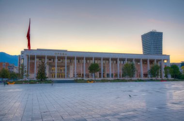 TİRAN, ALBANIA, SEPTEMBER 29 Eylül 2019: Arnavutluk 'un Tiran kentindeki Skanderbeg meydanındaki kültür sarayının gün doğumu manzarası