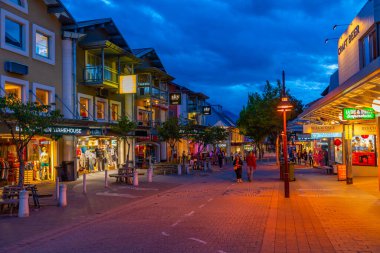 QUEENSTOWN, NEW ZEALAND, 27 HAZİRAN 2020: Queenstown, Yeni Zelanda 'nın merkezinde gezinen insanların gün batımı görüntüsü