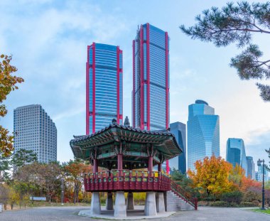 SEOUL, KOREA, 10 Kasım 2019: Kore Cumhuriyeti 'nin Seul kentindeki Yeouido adasında arka planda gökdelenleri olan ahşap pavyon