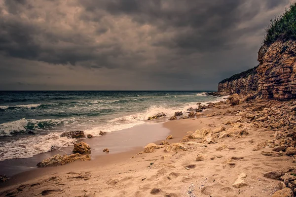 Denizin dalgaları ile üzerinde dramatik günbatımı