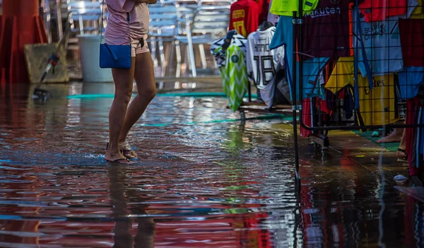 Su basmış bir cadde boyunca insanlar yürümek