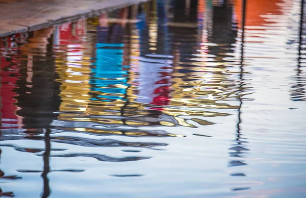 Reflection ,people walk along a flooded street