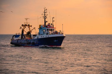 Gündoğumu ve açık denizde balıkçı teknesi