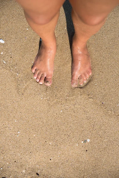 Headshot of man\'s feet on sandy beach