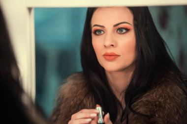 Güzel kız uygulanan makyaj ve ayna önünde ayakta