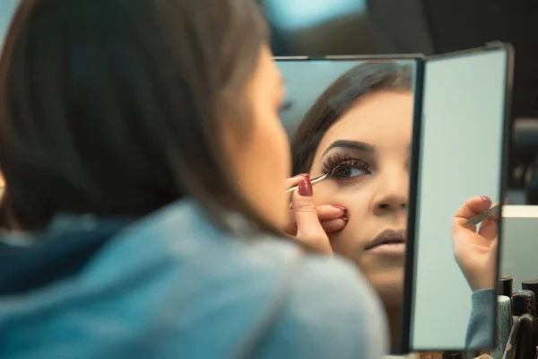 美丽的女孩站在镜子前 并应用化妆 — 图库照片
