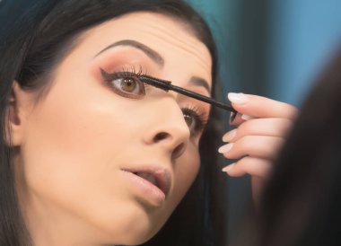 Güzel kız uygulanan makyaj ve ayna önünde ayakta