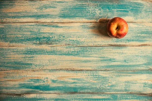 Ripe red apple on old painted wooden table