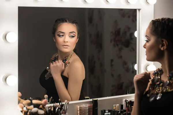 十几岁的女孩看着镜子应用化妆 — 图库照片