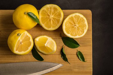 Sarı limon ve bir kesme tahtası yapraklarda