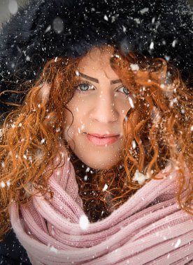 Kırmızı kıvırcık saçlı güzel kız kar düşüyor gibi poz