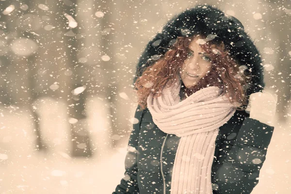 Kırmızı kıvırcık saçlı güzel kız kar düşüyor gibi poz