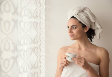 Kahve içme duştan sonra bir havlu ile sarılmış kız