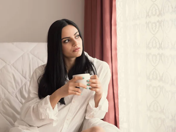 Chica Con Pelo Negro Está Sentado Junto Ventana Beber —  Fotos de Stock