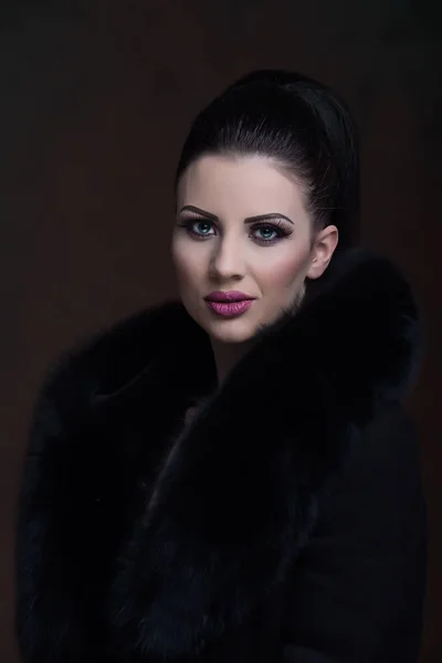 Portrait of a pretty girl with a black fur
