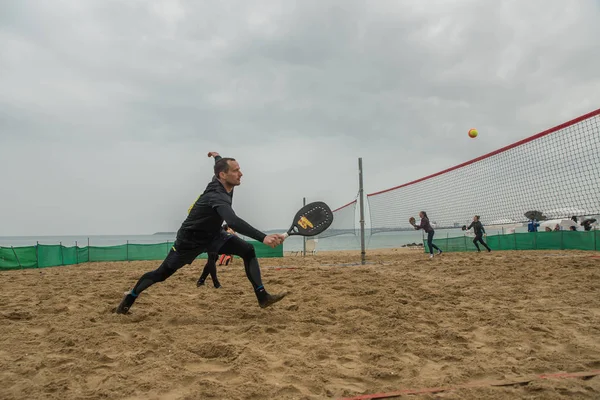 Mladí muži hrají plážový tenis — Stock fotografie