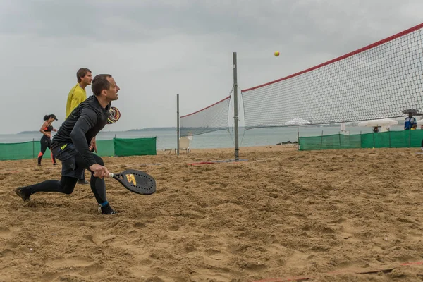 Mladí muži hrají plážový tenis — Stock fotografie