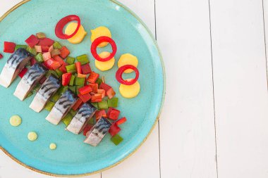 Beyaz bir tencerede turkuaz tabaktabaktabaktabaktabak tabaktabak tabaktabak sebze balık parçaları