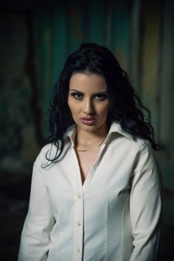 Terk edilmiş bir binada poz veren güzel bir kız, mistik bir bakış.