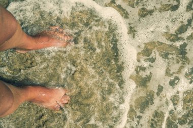 Kumsalda bir adamın ayaklarının vesikalığı.