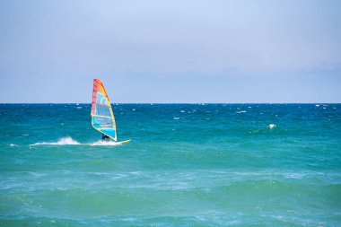 Pomorie, Burgaz / Bulgaristan -08.01.2020: Erkek sporcu deniz dalgaları üzerinde rüzgar sörfü yapıyor