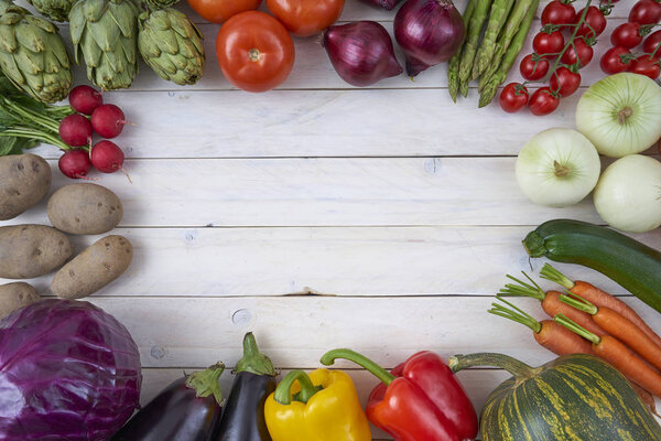 Top view of vegetables for posters and healthy food menus on white wooden background. Organic agricultural products. Vegan food. Veggies. Fresh vegetables