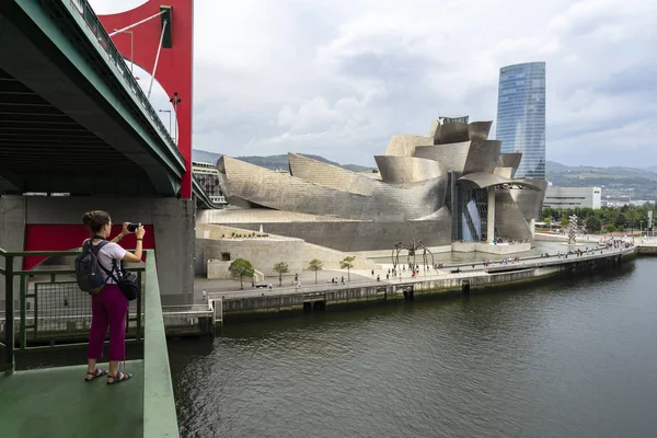 Turista tomando fotos con móvil del museo Guggenheim. Fotografía de viaje. Concepto de fotografía . Imágenes de stock libres de derechos