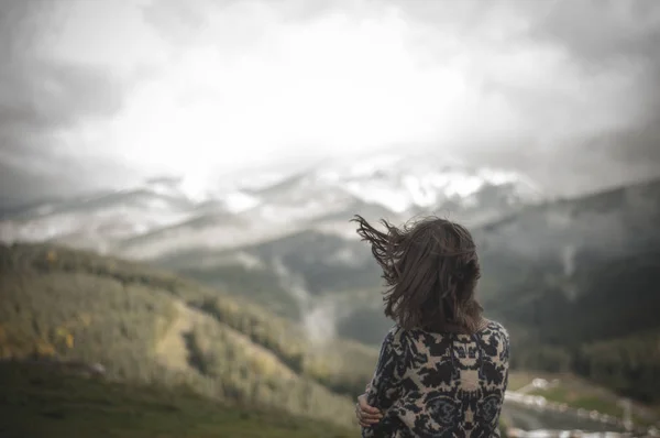 Meisje in de wind in de bergen — Stockfoto