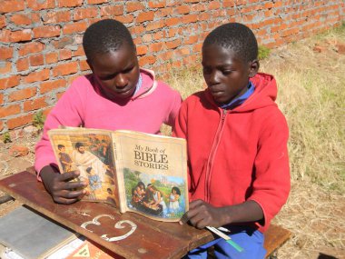 Norton, Zimbabwe, 15 Mayıs 206. A yakın çekim ücretsiz Jehova'nın tanık tarafından çıkarılan bir İncil hikaye kitabı okuma skolastik çocukların.                             