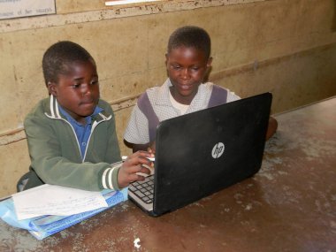 Norton, Zimbabwe, 4 Ekim 2017. Öğrenme nasıl bir sınıf içinde bir dizüstü bilgisayar kullanmak iki Afrika ilkokul çocukları okul                                  