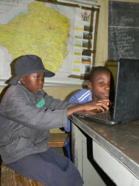 Norton, Zimbabwe, 10 Ekim 2017. İki Afrika birincil çocuklar Zimbabve Haritası ile bir sınıfta eğitim için bir dizüstü bilgisayar kullanarak oturmuş. Bunun kullanımı Zimbabveli okullarda artmıştır. 