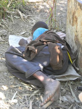 Harare,Zimbabwe.April 27 2015. Bir ağacın altında yere uyku yalınayak evsiz bir çocuk. Hızlı kentleşme evsizlik kasaba ve şehirlerde dünya çapında artmıştır.                               