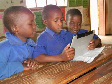   Norton, Zimbabwe, 19 Ocak 2016.Three ilkokul çocukları bir sınıfta bir tablet (cep telefonu) kullanma. ICT Eğitim düşünce Dünya çehresini değiştirdi.                             