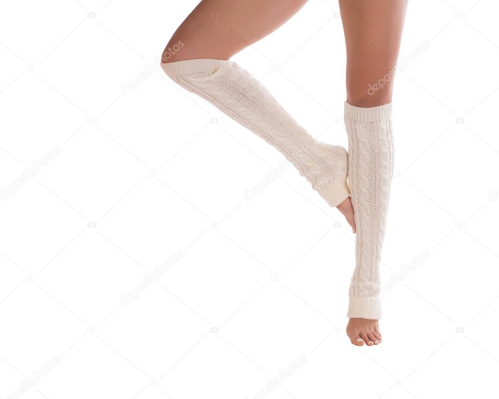 Female slim legs in white leg warmers. White pedicure. Close up, isolated on white background