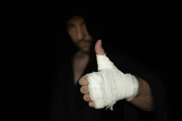 Taped fist of professional boxer. Boxer gesturing his thumb up. Boxing preparation before rumble