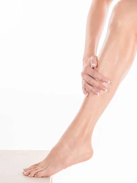Kobiece dłonie masaż nogę z kremem do ciała, z bliska — Zdjęcie stockowe