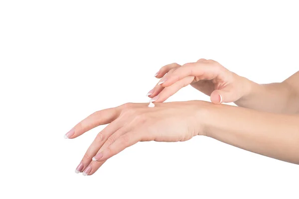 Mãos femininas aplicando creme de mão, fundo branco, close-up — Fotografia de Stock