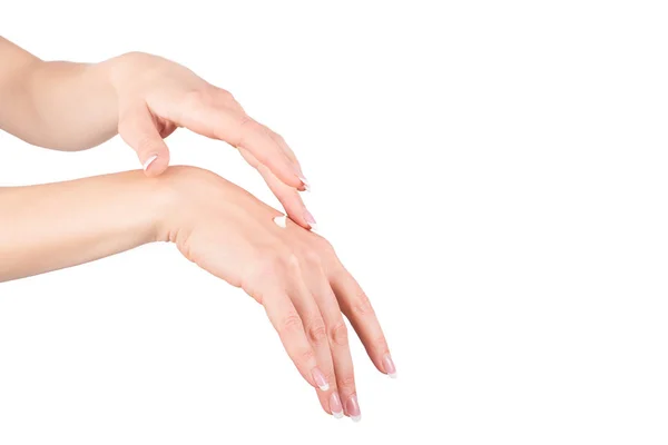 Руки женщины наносят крем для рук, белый фон, крупный план — стоковое фото