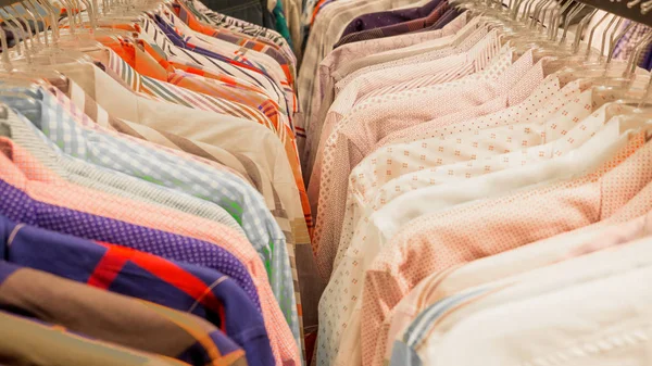 Overhemden diverse kleuren hangen in de winkel. Shirts op hangers in kledingwinkel. — Stockfoto