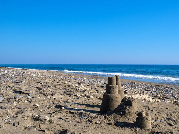 песчаный замок на пляже, спокойное красивое море
