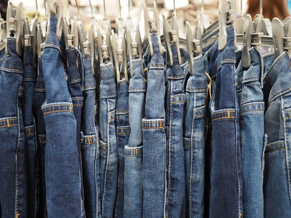 Сині джинсові штани на вішалці підряд, крупним планом . — стокове фото