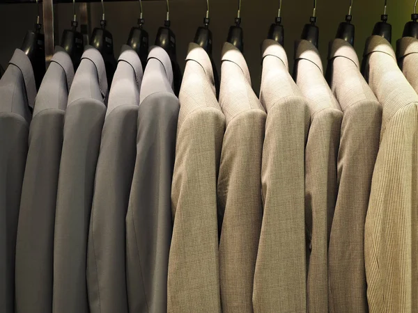 Rij van mannelijke pak jassen in kleding opslaan — Stockfoto