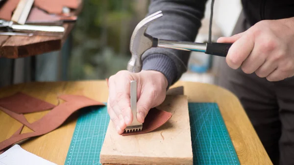 Tanneurs mains au travail avec coup de poing, marteau et cuir. Focus sélectionné, gros plan . — Photo