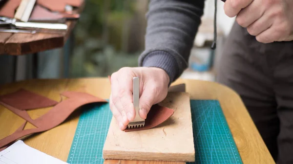 Tanneurs mains au travail avec coup de poing, marteau et cuir. Focus sélectionné, gros plan . — Photo