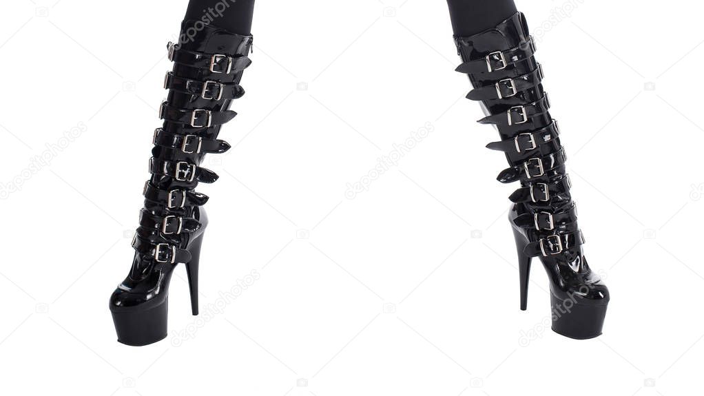 Sexy female legs in shiny black fetish high-heeled boots, isolated on white, front view