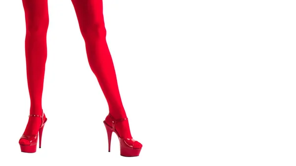 Sexy piernas femeninas en medias rojas fetiche y tacones altos rojos, aislado en blanco, entretenimiento, espectáculo —  Fotos de Stock